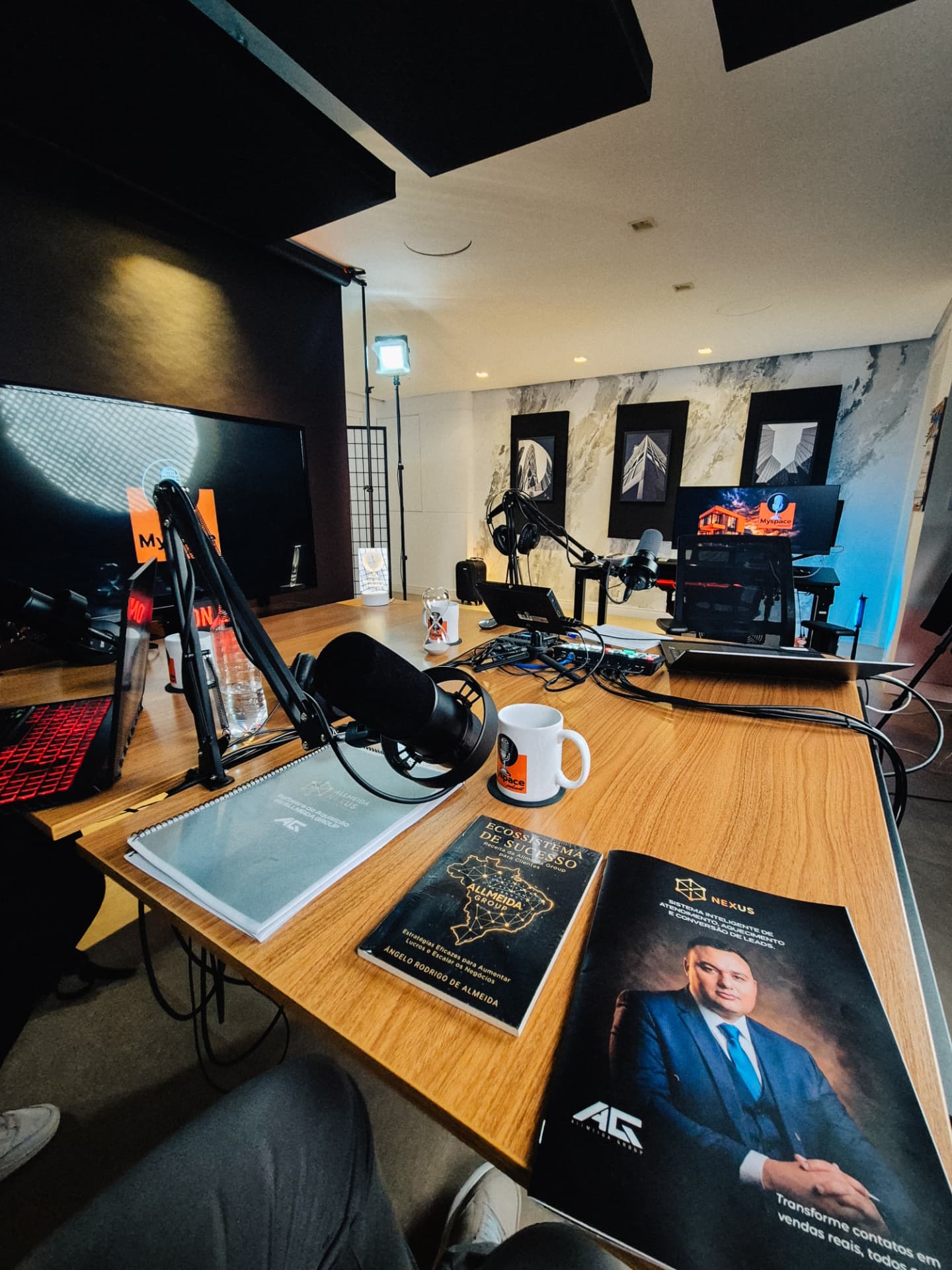Estúdio de podcast montado com microfones, iluminação e materiais da Allmeida Group